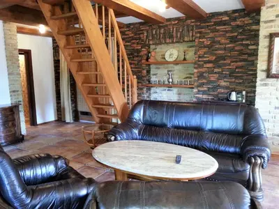 a living room with leather furniture and a table at Ubytování Steak-Hredle in Hředle