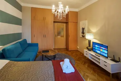 a living room with a blue couch and a television at Dlouhá Apartment with balcony in Prague