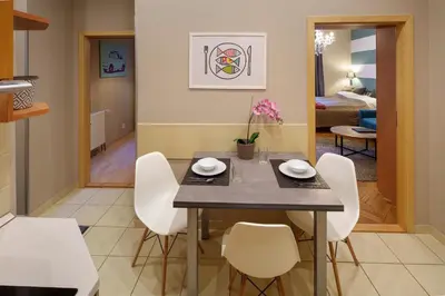 a dining room with a table and white chairs at Dlouhá Apartment with balcony in Prague