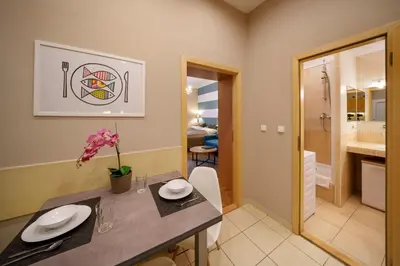 a dining room with a table and a bathroom at Dlouhá Apartment with balcony in Prague