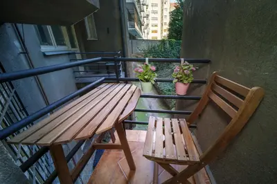 a wooden table and a bench on a balcony at Dlouhá Apartment with balcony in Prague