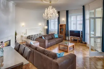 a living room with couches and a chandelier at Smetanovo nábřeží - Riverview Old Town Apartment in Prague