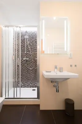 a bathroom with a sink and a shower at Bear Fountain Residence in Prague