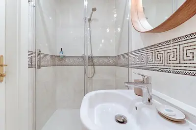 a white bathroom with a sink and a shower at Bear Fountain Residence in Prague