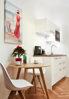 a kitchen with a wooden table and white cabinets at Bear Fountain Residence in Prague