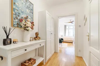 a living room with a white dresser and a vase of flowers at Bear Fountain Residence in Prague