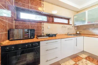 a kitchen with white cabinets and a microwave at Apartmán blizko centra Prahy in Prague