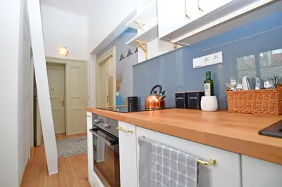 a kitchen with a wooden counter top and blue walls at Lovely little cosy Apt in Prague in Prague