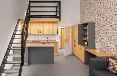 a kitchen with a staircase leading up to a loft at Mordecai 12 Apartments by Adrez in Prague