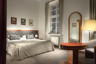 a bedroom with a bed and a table and a mirror at Hotel Pod Věží in Prague