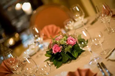 a table with glasses and a bouquet of pink roses at Hotel Pod Věží in Prague