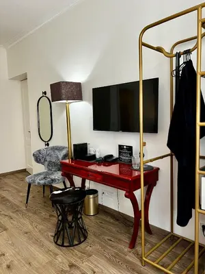 a room with a red desk and a television at Antik Hotel Prague in Prague