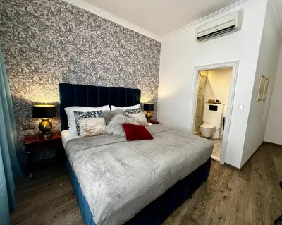 a bedroom with a large bed with a blue headboard at Antik Hotel Prague in Prague