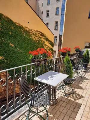 a table and chairs next to a fence with flowers at Antik Hotel Prague in Prague