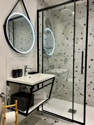 a bathroom with a shower and a sink and a mirror at Antik Hotel Prague in Prague
