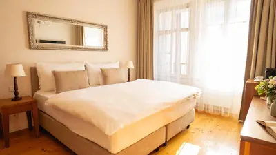 a bedroom with a large bed with a mirror on the wall at Hotel Golden Key Prague Castle in Prague