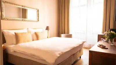 a bedroom with a large white bed and a window at Hotel Golden Key Prague Castle in Prague