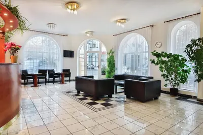 a lobby with chairs and tables and windows at Attic Hotel in Prague
