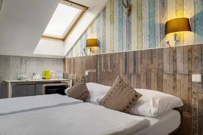 a bedroom with a bed with two pillows at Royal Court Hotel in Prague