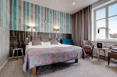 a hotel room with a bed and a chair at Royal Court Hotel in Prague