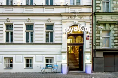 a white building with two chairs in front of it at Royal Court Hotel in Prague