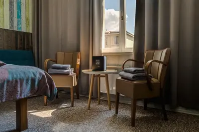 a bedroom with two chairs and a table and a window at Royal Court Hotel in Prague