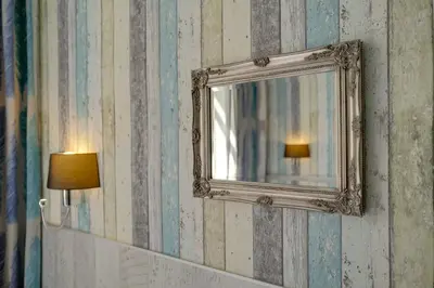 a mirror on a wall next to a lamp at Royal Court Hotel in Prague