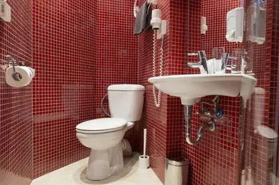 a red tiled bathroom with a toilet and a sink at Royal Court Hotel in Prague