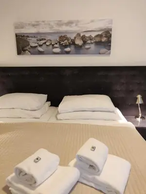 a bedroom with two beds with towels on them at Hotel Oya in Prague