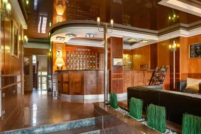 a lobby with a library with wood paneling at Hotel Oya in Prague