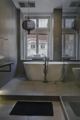 a bathroom with a tub and two sinks and a window at Friday Hotel in Prague