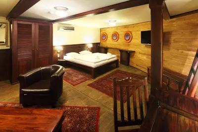 a bedroom with a bed and a chair and a television at Boat Hotel Matylda in Prague