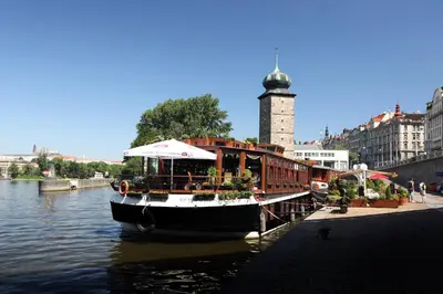a boat is docked in the water in a city at Boat Hotel Matylda in Prague