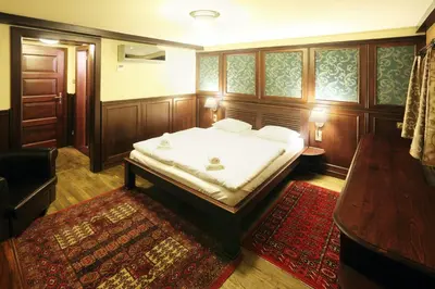 a bedroom with a bed and a table and a rug at Boat Hotel Matylda in Prague