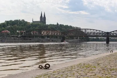 a bridge over a river with two objects in the water at Augustus et Otto Hotel in Prague