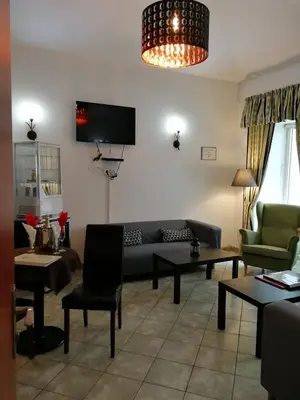 a living room with a couch and a tv at Augustus et Otto Hotel in Prague