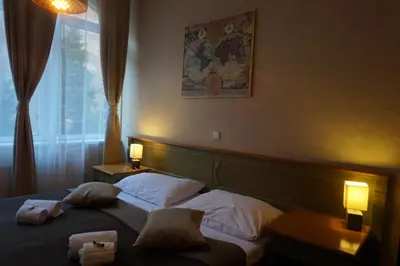 a bedroom with two beds and two lamps and a window at Augustus et Otto Hotel in Prague
