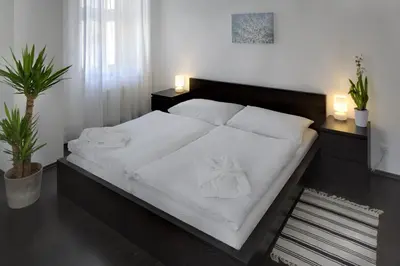 a bedroom with a large bed with white sheets at 1.Republic Hotel in Prague