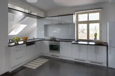 a kitchen with white cabinets and a window at 1.Republic Hotel in Prague