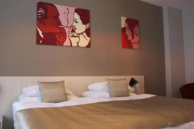 a bedroom with a bed with two pictures on the wall at 1.Republic Hotel in Prague