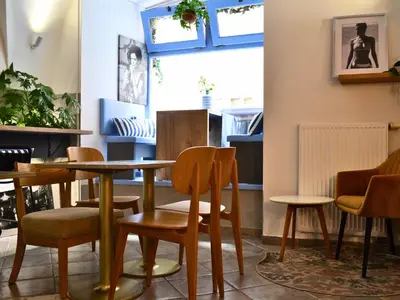 a dining room with tables and chairs and a window at Chateau 9 Apartments by Adrez in Prague