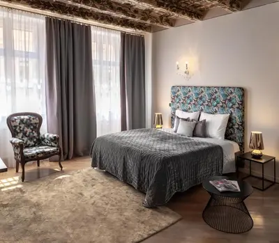 a bedroom with a bed and a chair and windows at Chateau 9 Apartments by Adrez in Prague