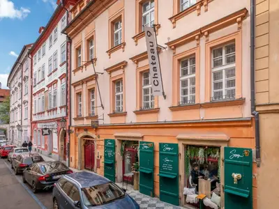 a street with cars parked in front of a building at Chateau 9 Apartments by Adrez in Prague