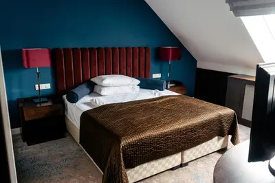 a bedroom with a bed with blue walls and two lamps at The Hotel Fitzgerald in Prague