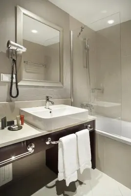 a bathroom with a sink and a tub and a mirror at The Hotel Fitzgerald in Prague