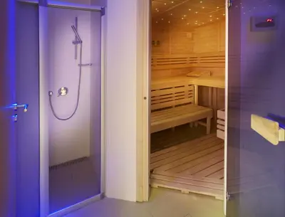 a walk in shower in a bathroom next to a walk in closet at The Hotel Fitzgerald in Prague