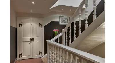 a staircase with a white door and a vase of flowers at Mostecká 12 Residence in Prague