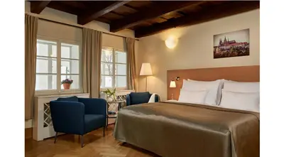 a hotel room with a bed and two chairs at Mostecká 12 Residence in Prague