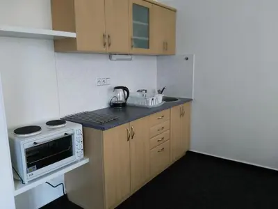 a small kitchen with a stove and a microwave at Apartman Amanda in Poděbrady
