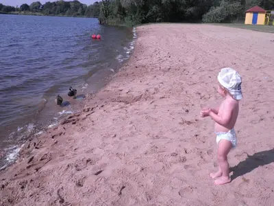 a young child standing on a beach near the water at Apartman Amanda in Poděbrady